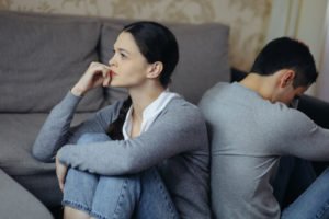 Married couple sitting down but facing away from each other