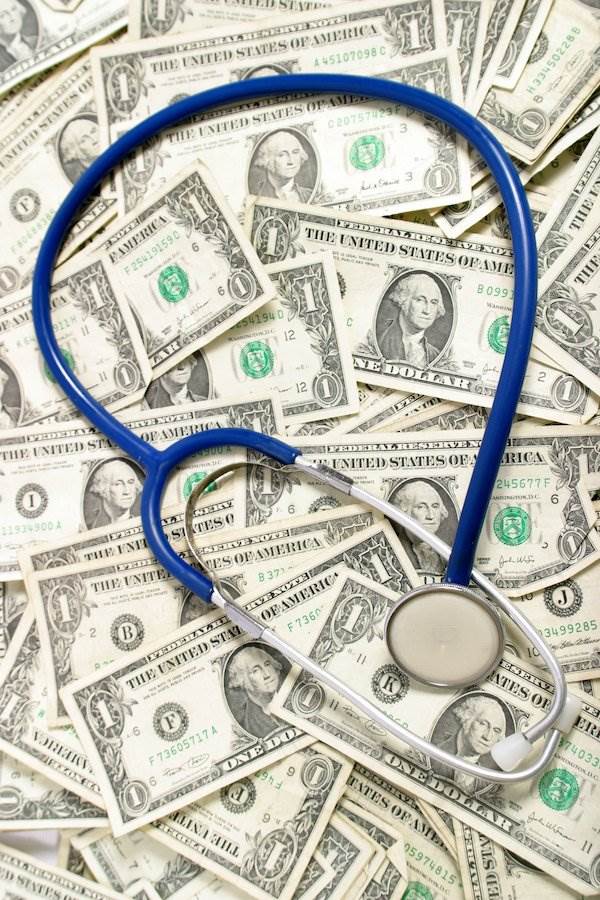 stethoscope against wall of cash