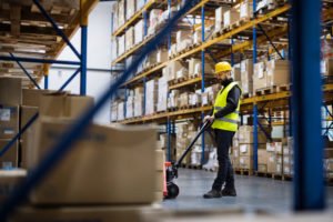 A warehouse worker using a forklift to move merchandise.