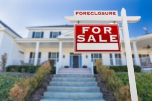 Home that says "forclosure: for sale"