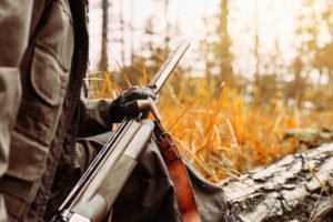 Cazador con rifle en el bosque