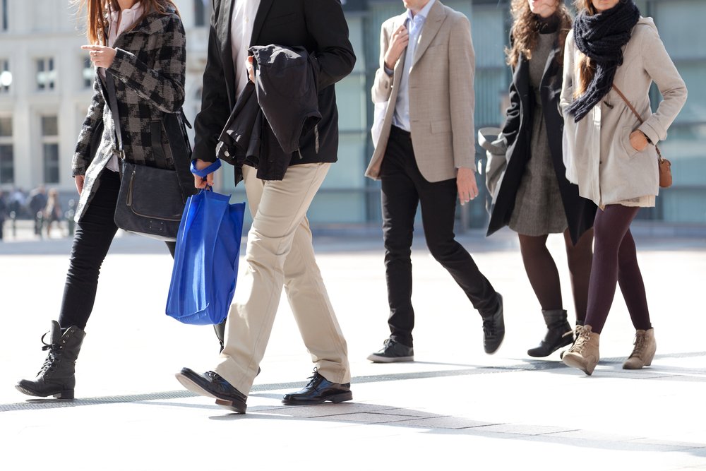 Pedestrians crossing the street, on an unmarked crosswalk.