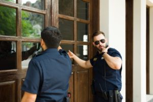 Police knocking on the home door with a search warrant to do an investigation and look for criminal evidence