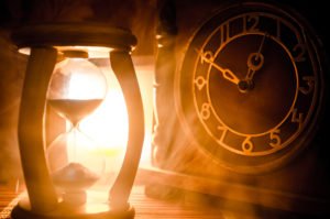 An hourglass next to a clock, representing the passage of time to request an early termination of probation.