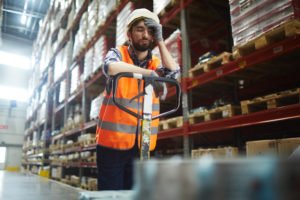 A tired warehouse worker taking a momentary break.