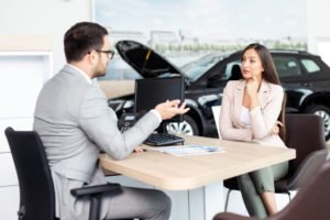 A car salesman negotiating with a buyer, which may result in a higher commission for him if he is successful.