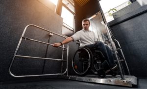Man in a wheelchair in a special elevator that was provided as a reasonable accommodation for his job