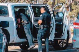 Police officers searching a vehicle.