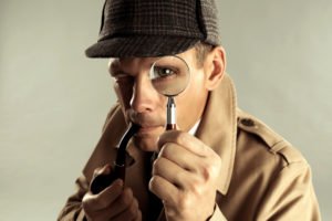 A detective using a magnifying glass to hone in onto something he is suspicious about.
