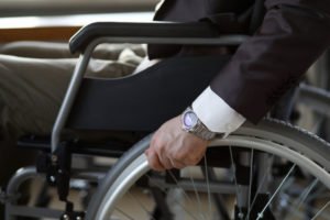 Close-up of a man in business suit riding in his wheelchair