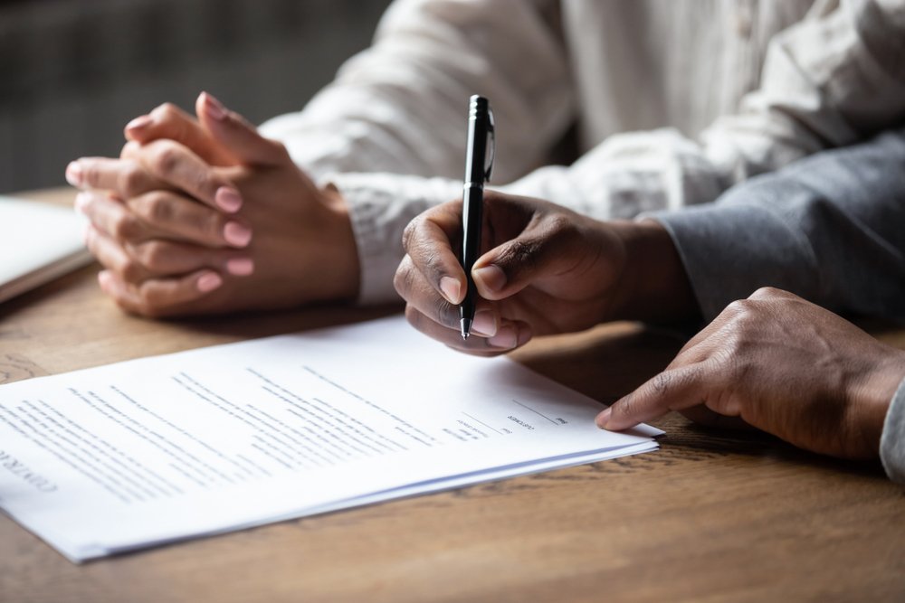 A new hire signing his employment contract, or potentially an independent contractor agreement.