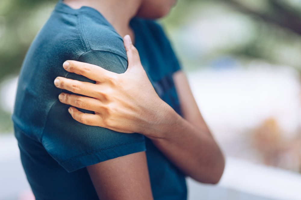 A man holding his shoulder in pain after an auto accident.