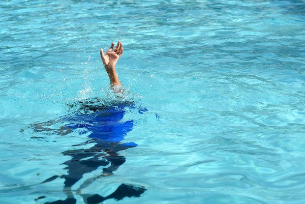 Boy struggling underwater drowning in swimming pool.