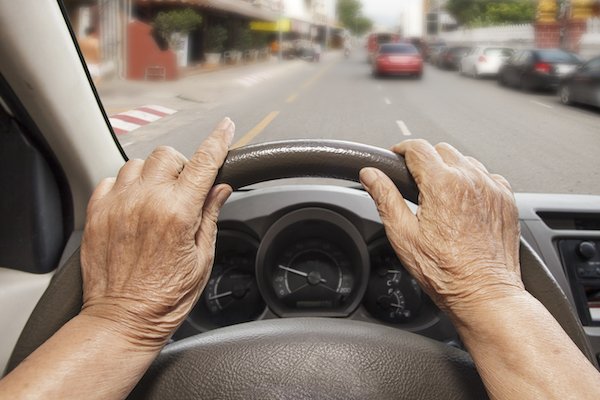 Closeup de manos de ancianos detrás del volante