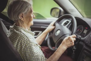 Mujer mayor conduciendo un coche