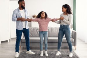 Divorcing parents grabbing their child's arms