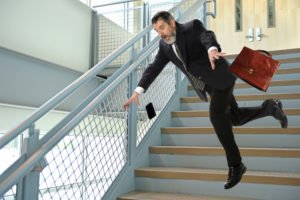 A man falling down a stairwell, after possibly slipping on something.
