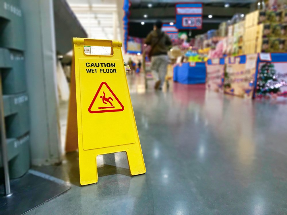 A "Caution Wet Floor" sign inside of a big box store, perhaps a Walmart.