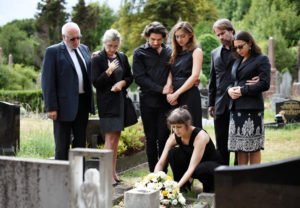 Family members of the deceased gathered around during the funeral. Some of the members may have standing to pursue a wrongful death claim.