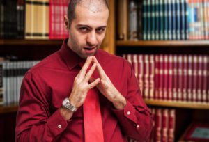 Persona siniestra que no es abogado frente a una estantería con libros legales