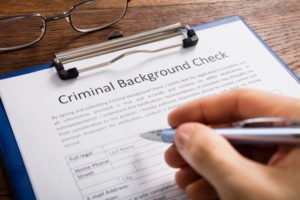 Clipboard with paper that says "criminal background check"