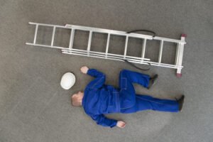 Trabajador en el suelo con escalera después de caerse del tejado