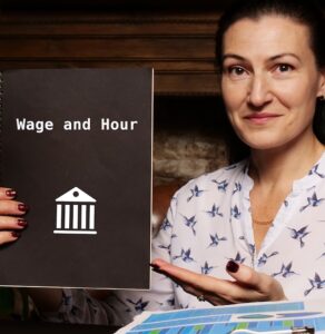 Woman holding a book saying "wage and hour"