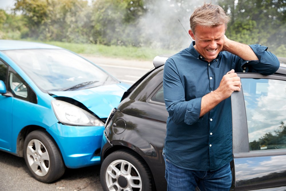 A whiplash victim holding his neck in pain after a car accident.