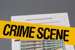 Unemployment benefits application with crime scene tape.