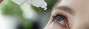 Close-up of eye drop being dispense into woman's eye
