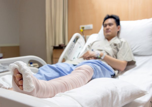 patient with broken leg in hospital bed