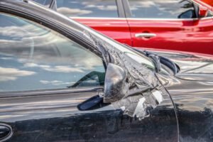 Aftermath of sideswipe accident with a mirror that has been taped back on