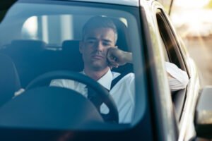 Sad driver behind the wheel of a car