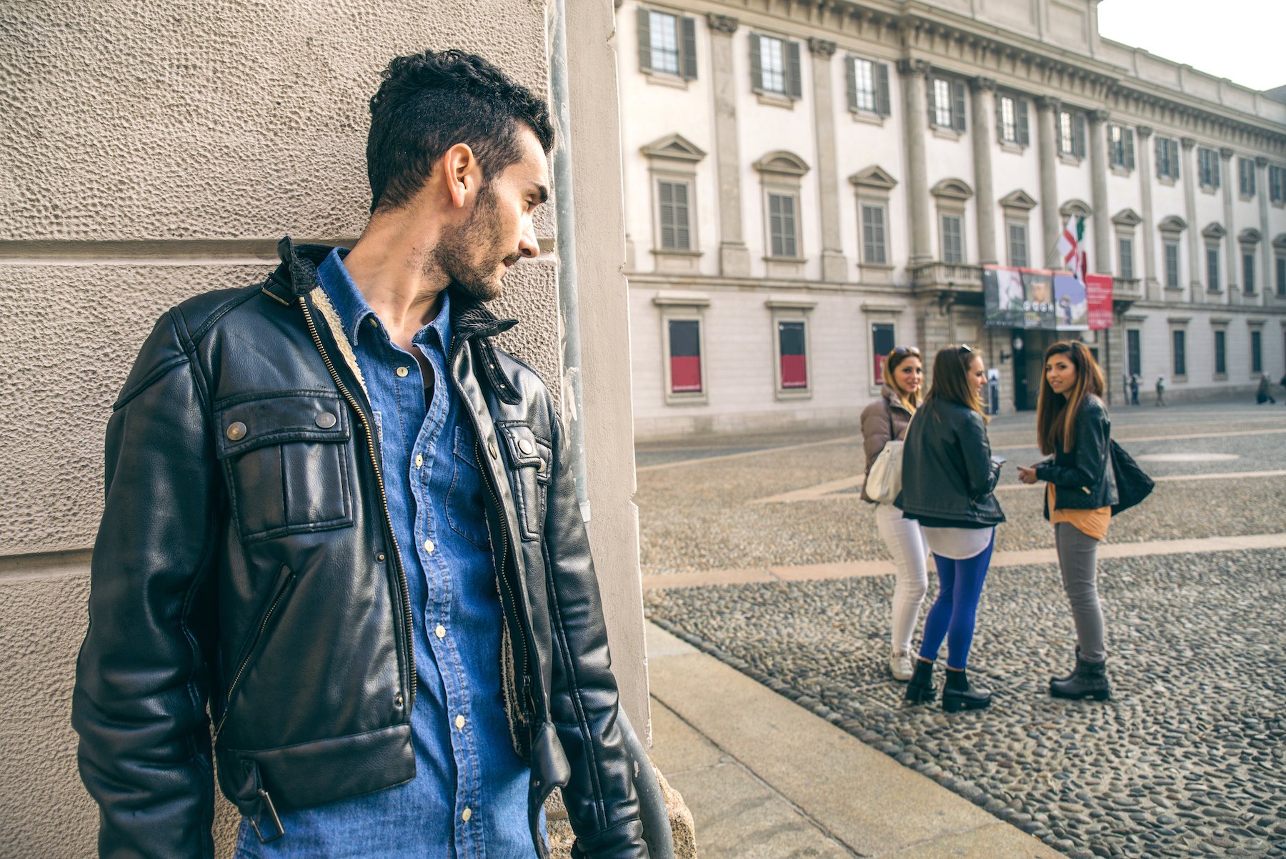 Man looking menacingly at three girls in a public square