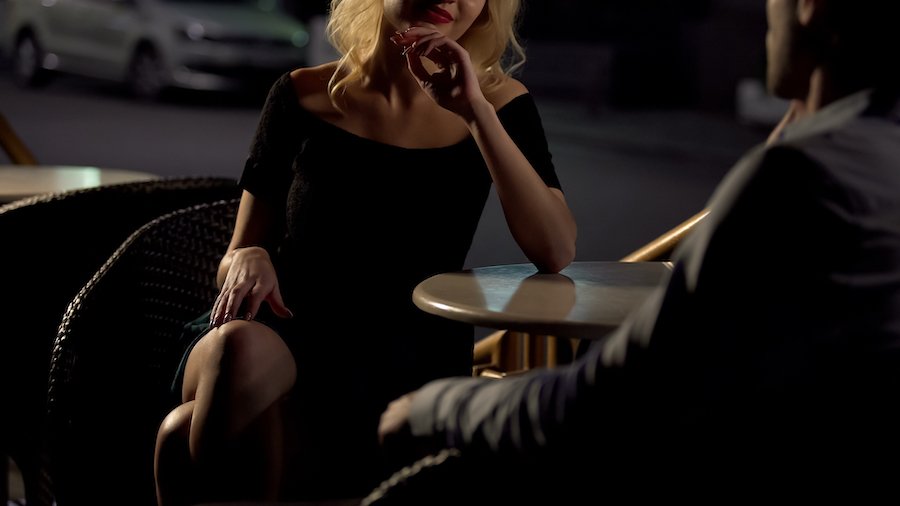 Pretty escort and a "john" on a "date" at an outdoor cafe at night