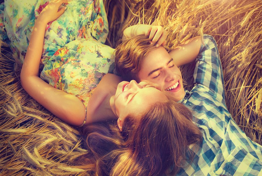 Bird's eye view of young couple cuddling on a bed of hay