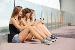 Three teen girls staring at their phones