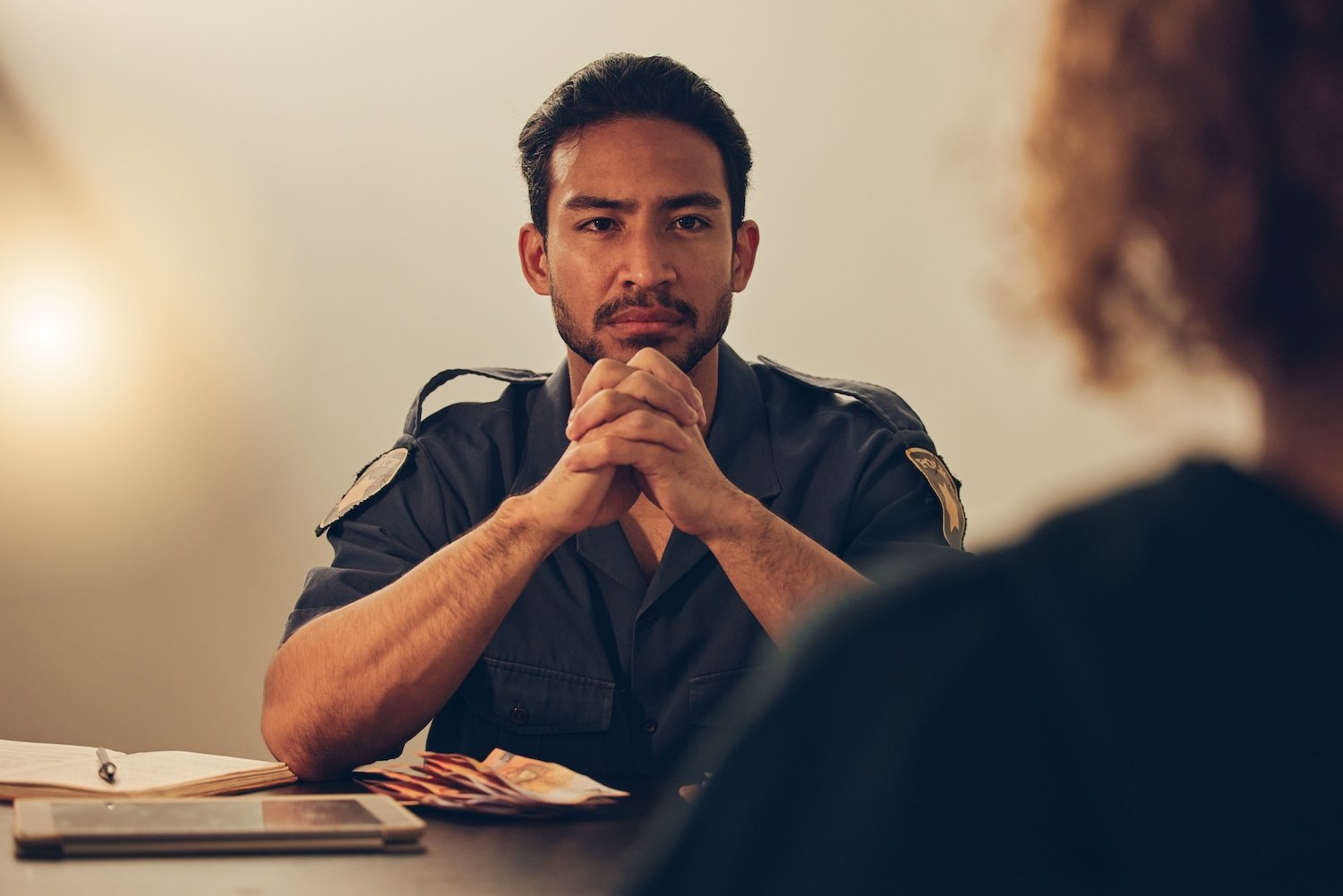 Oficial de policía sentado en una mesa hablando con un delincuente sexual