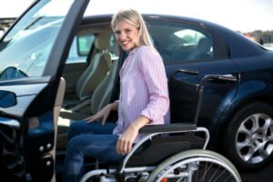 Mujer discapacitada haciendo un acercamiento seguro a su automóvil en el espacio de estacionamiento para personas con discapacidad física
