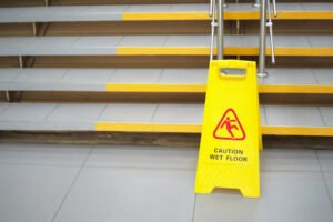 Yellow "caution wet floor" sign by stairs in public place
