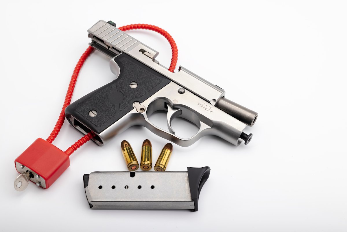 Pistola con un mecanismo de bloqueo en el gatillo sobre fondo blanco