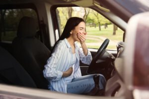 Woman with reflux behind the wheel of a car