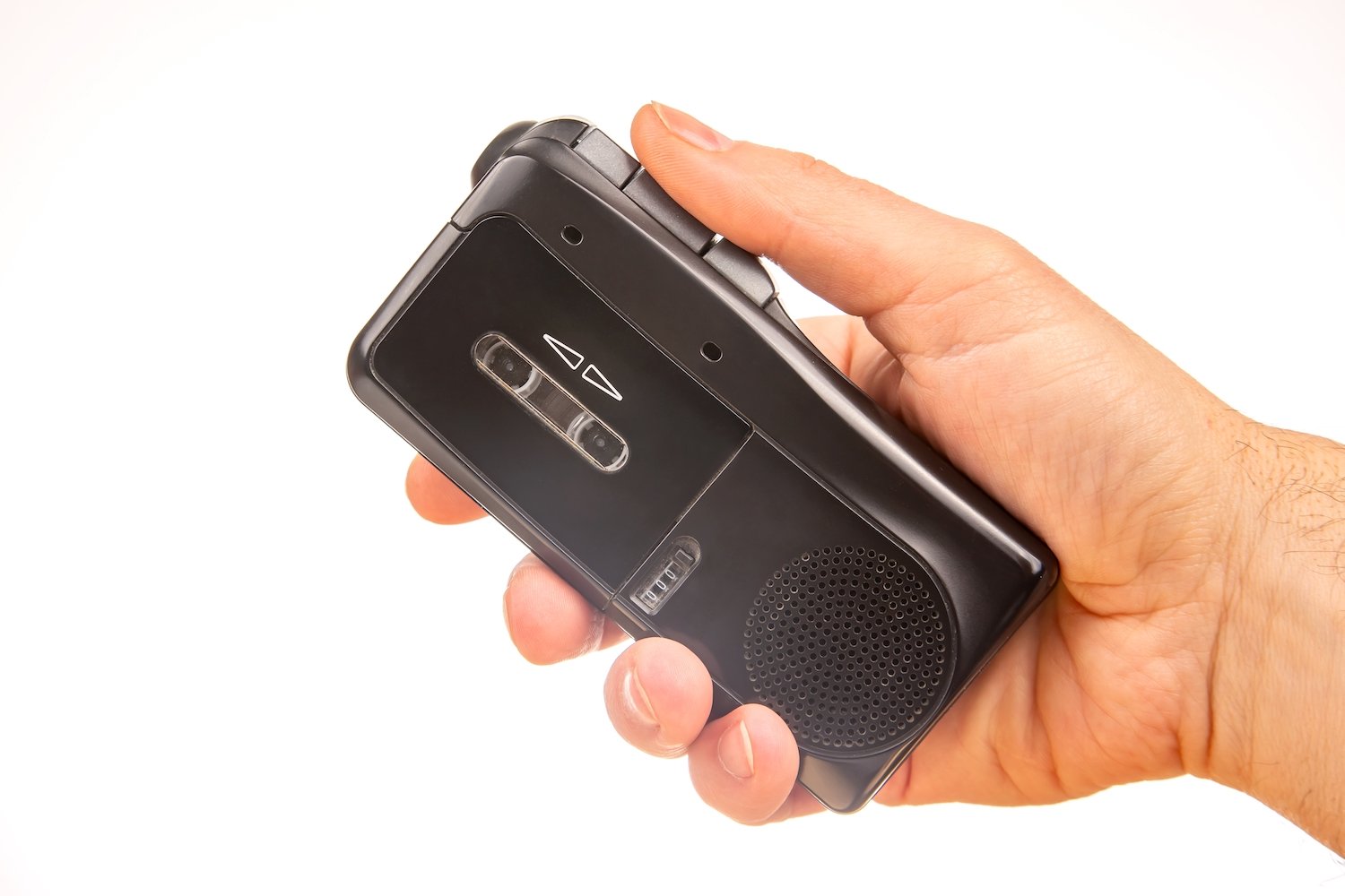 Hand holding an old-fashioned tape recorder against a white background