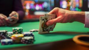Man's hand looking at cards during blackjack game