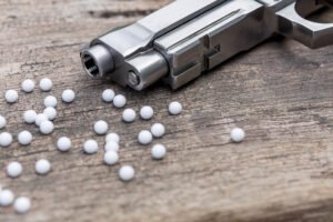 BB gun on a table with BB pellets