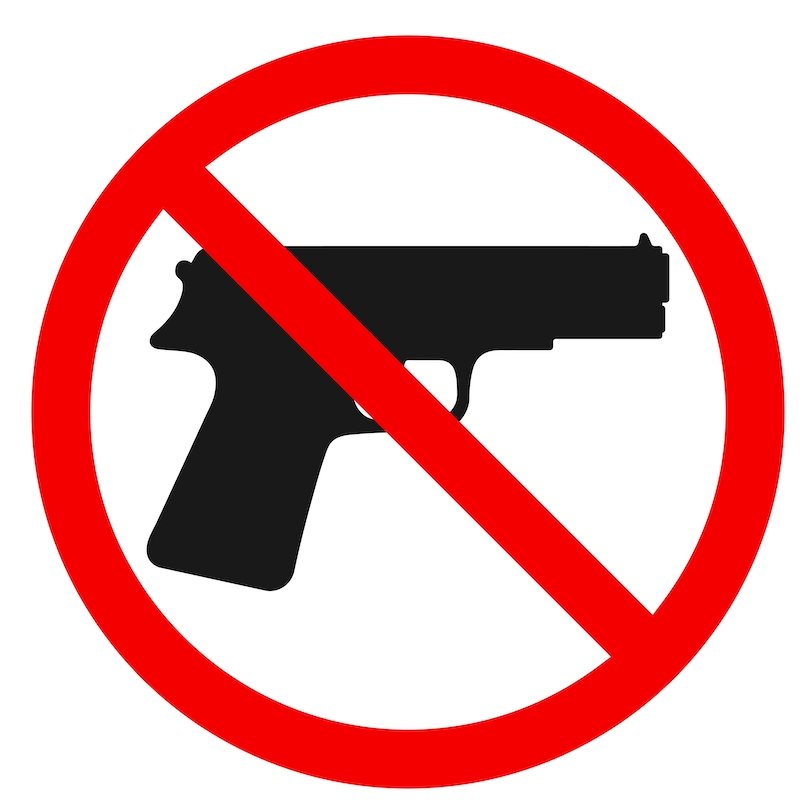 Ilustración de una pistola con una línea roja a través de ella contra un fondo blanco