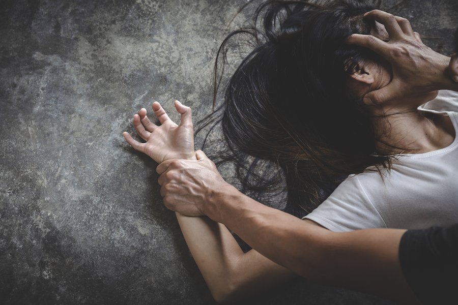 Man holding down woman on the floor