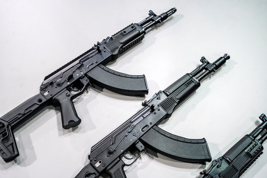 Three machine guns against a white background