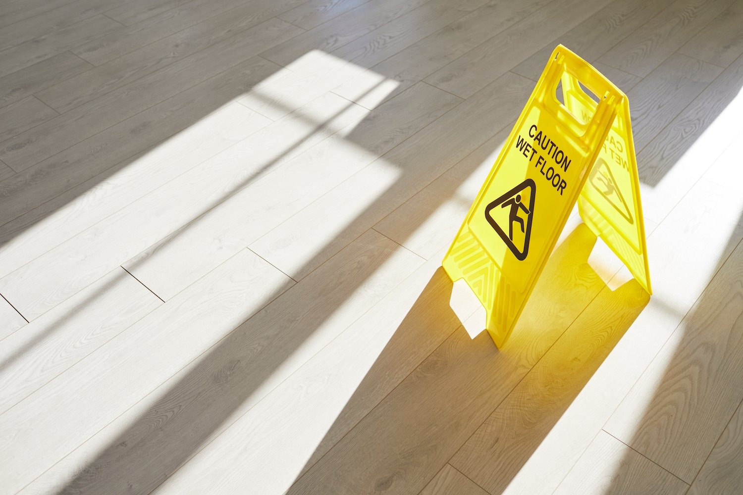 Yellow "Caution: Wet Floor" sign on an office floor