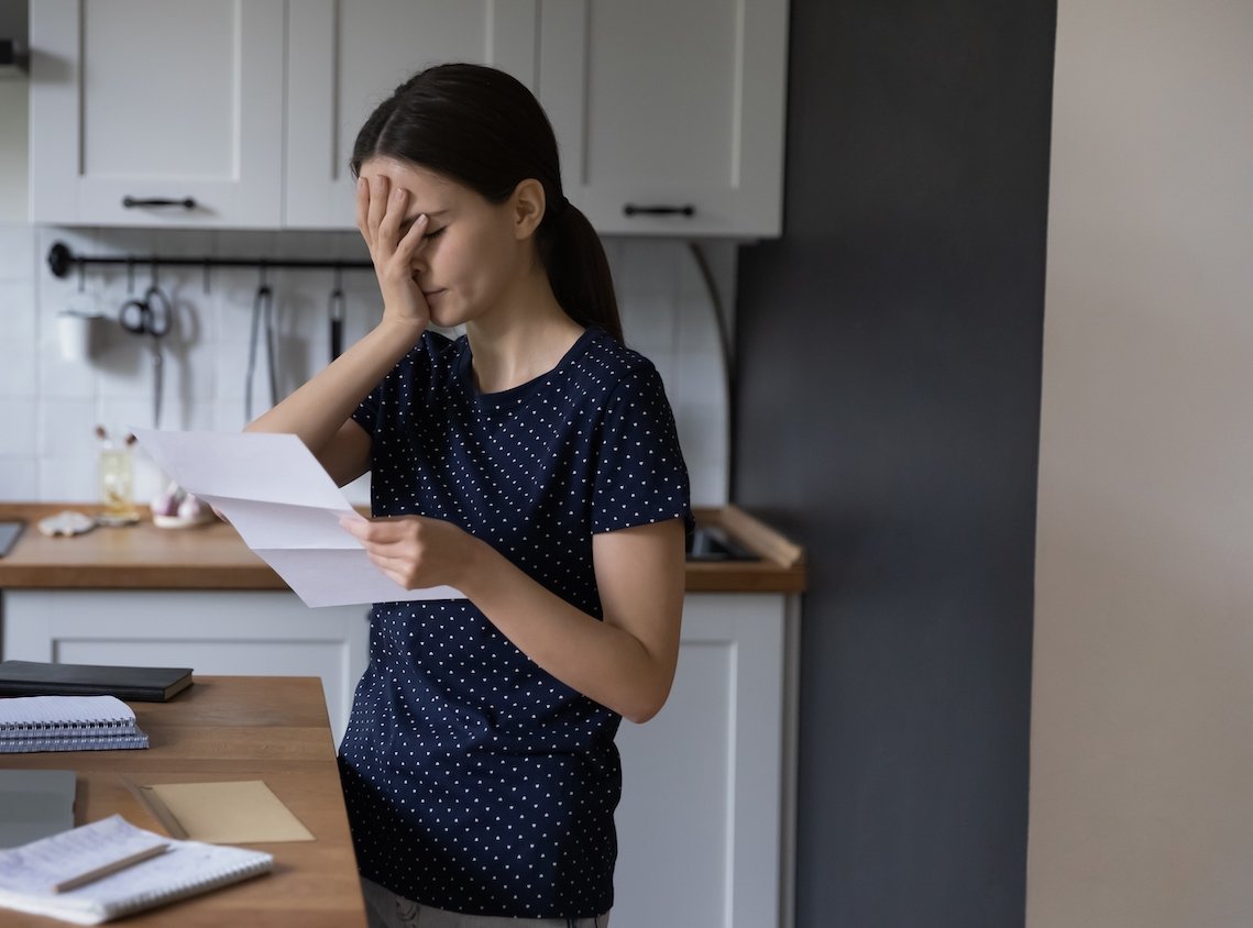 Woman looking upset in her kitchen after getting subpoenaed 